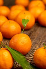 Unpeeled tangerines stacked together, a large number of ripe orange tangerines on the table