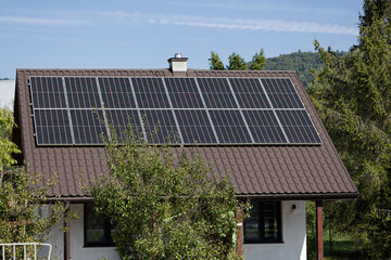 Tiny house at countryside with solar panels photovoltaic on the roof. Poland, Europe.