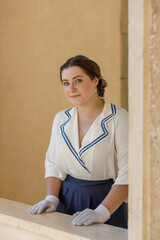 A girl stands with a suitcase in her hands on the embankment of the river station, port.