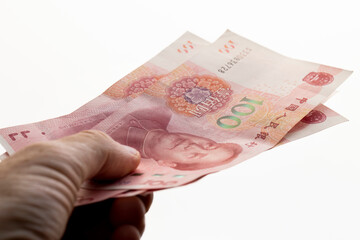holding red Chinese yuan in a hand on a background, holding a large amount of money in yuan in the hands of a man