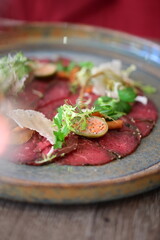 Raw beef with fresh herbs and spices on a wooden plate. Restaurant SERVING  FOOD, 