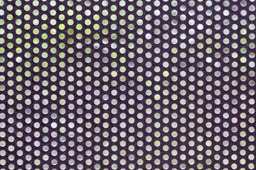Close-up of a perforated metal sheet with circular holes.