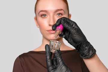 Woman applying beauty product in a professional setting using a dropper with a focus on skincare...