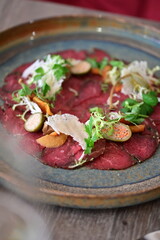 Raw beef with fresh herbs and spices on a wooden plate. Restaurant SERVING  FOOD, 
