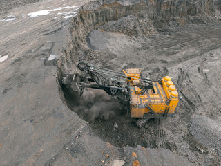 Open pit mine with industrial excavator in operation, removal overburden soil for new ore deposit...