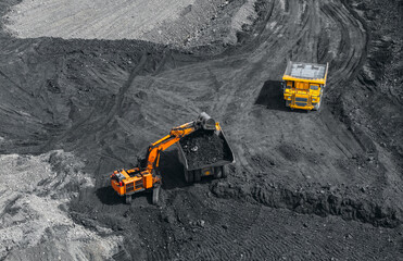 Aerial view of open pit coal mine with excavator and dump truck in action
