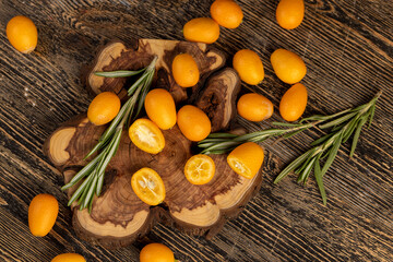 fresh sweet kumquat cut into halves close up, sliced orange kumquat fruits lie on the table during cooking