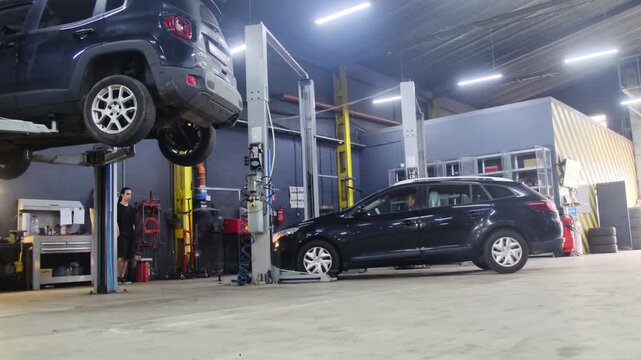 Vehicle pulls up to repair site in special spacious garage. Driver parks near equipment and specialists before work process begins