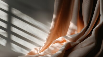 Close-up of a curtain with a light orange fabric draped over it. the fabric appears to be made of a soft, silky material and has a subtle sheen.