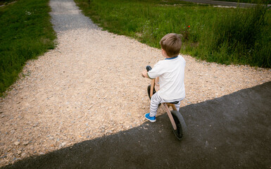 Fototapeta premium Boy has great fun riding a balance bike while learning to balance on a bike