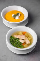 Delicious soups in white bowls