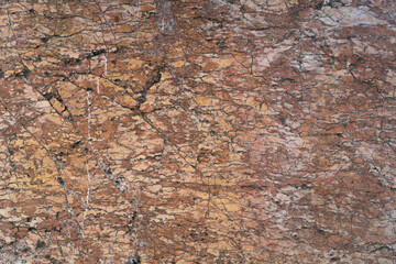 Textured surface of natural stone reveals intricate patterns and warm hues, highlighting the beauty of geological formations and unique characteristics of mineral deposits found in nature's landscape