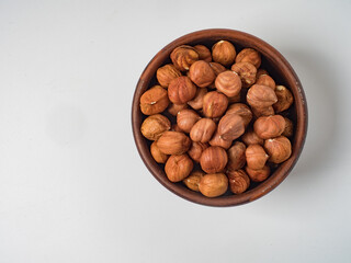 Raw hazelnuts without shells in a bowl on a white background
