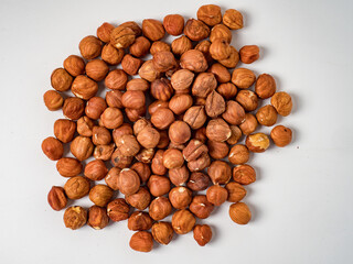 Raw hazelnuts without shells in a bowl on a white background
