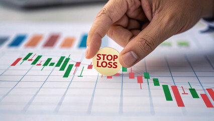 Proactive risk management concept with hand holding stop loss sign over financial chart