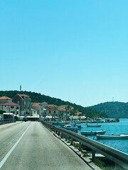 Scenic coastal Rogoznica road view with buildings and clear blue sky atmosphere in Croatia.