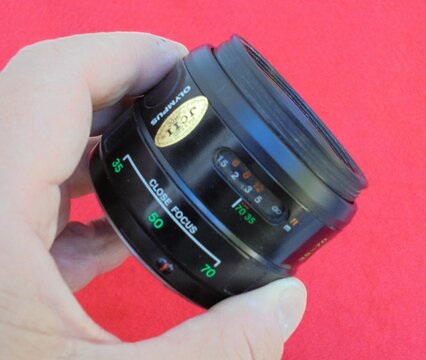 Photographer holding Olympus zoom lens with close focus setting
