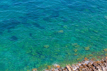 Light azure colour water with sand and pebbles on bottom