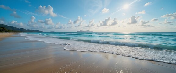 Panoramic tropical beach with turquoise ocean waves and brilliant sunlight