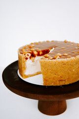 Delicious creamy dessert with caramel topping on a wooden pedestal during a celebration