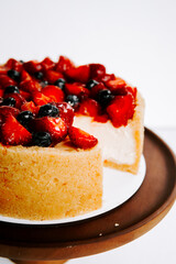 Delicious creamy cheesecake topped with fresh strawberries and blueberries for dessert lovers