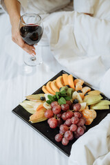 Wine and fruit platter in bed