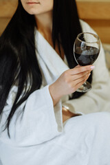 Woman in robe enjoying red wine
