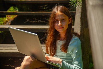 A barefoot girl enjoys quiet study time in nature.
