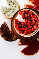Delicious assortment of colorful desserts displayed on a wooden serving board