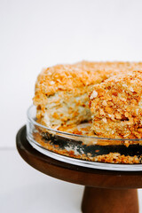 Delicious layered dessert with crushed nuts, displayed on a rustic wooden stand