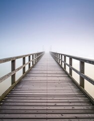 Obraz premium Wooden pier extending into a foggy landscape
