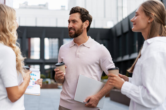 Business team discussing strategy during coffee break outside office building - Powered by Adobe