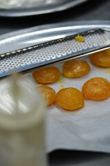 Close-up of a dried egg yolk and a grater on a rustic kitchen background, highlighting ingredients for a homemade recipe.