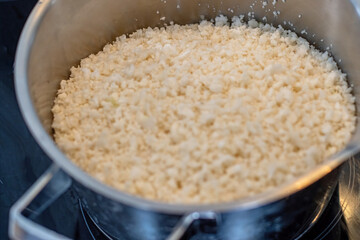 Cauliflower ground into small pieces using a blender in a steel pot.