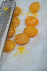 Close-up of a dried egg yolk and a grater on a rustic kitchen background, highlighting ingredients for a homemade recipe.
