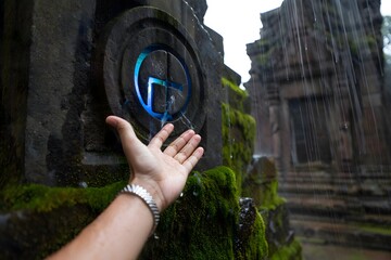 Exploring ancient ruins in the rain with a glowing symbol and hand reaching out to touch it