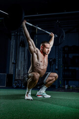 Muscular man having training with weights. Strong athletic man does workout. Concept bodybuilder doing exercises in gym.