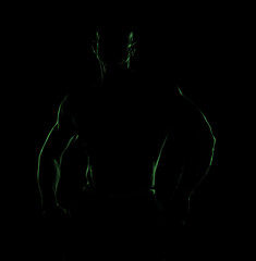 Silhouette of a muscular bodybuilder with powerful physique, dramatic backlight and hidden face in shadow against dark background