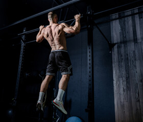 Muscular man having training with weights. Strong athletic man does workout. Concept bodybuilder doing exercises in gym.