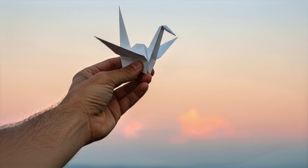 Hand holding origami crane against a pastel sky, delicate folds and soft light capturing serenity, craftsmanship, and the quiet beauty of mindful creation