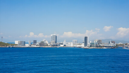 Scenic ocean view of a cityscape with modern buildings under a clear blue sky during daytime