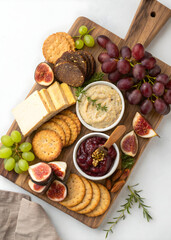 Delicious charcuterie board featuring cheese grapes figs crackers and savory dips snack food