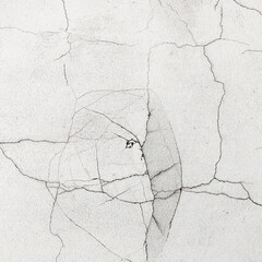 White wall with intricate cracks, representing structural damage from an earthquake, disaster, or building deterioration.