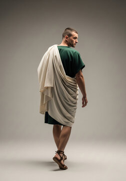 Ancient Roman man in green tunic with draped white toga, back view