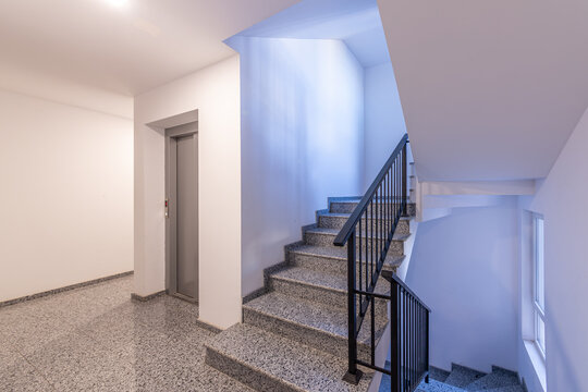 Modern apartment building lobby with staircase and elevator. Clean and bright interior of a residential complex hallway. Elevator and stairs in a modern building
