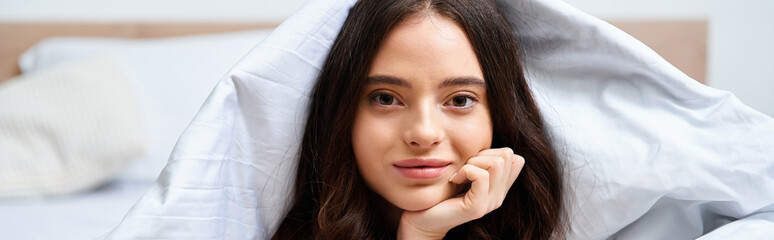 Relaxing in the cozy bedroom with a serene expression on a beautiful young woman