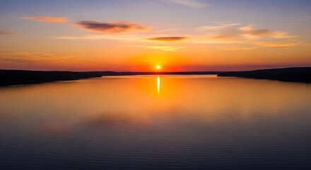 Sunset over calm lake water.