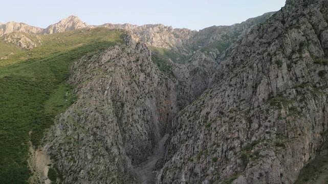 Warm sunrise touches jagged ridge and deep ravine in the Uzbekistan highland. The composition moves like a slow travel video, inviting exploration and a sense of wild freedom natural color and clean