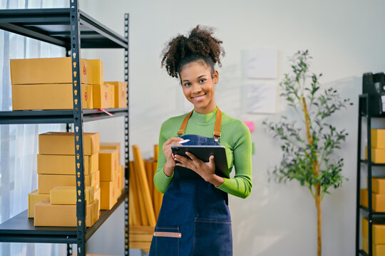 Young african american woman entrepreneur managing her small business using a tablet and stylus