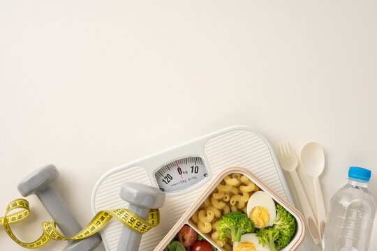A composition featuring healthy food, dumbbells, measuring tape, water bottle, and a weighing scale, symbolizing a balanced approach to fitness, healthy eating, and weight loss